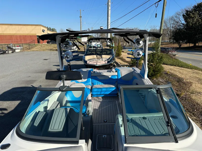 Slide: The Image of 2022 MB B52 23 Alpha boat with blue interior and open windshield, parked outdoors. - 7