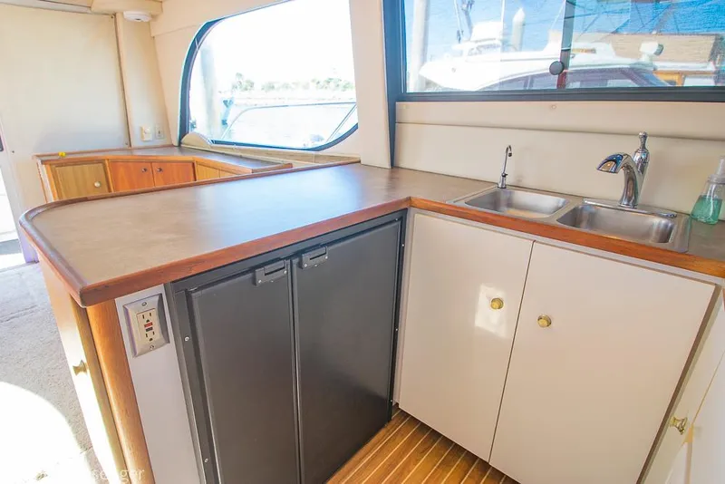 Slide: The Image of 2001 Bayliner 3788 Command Bridge Motoryacht kitchen with sink, counter, and cabinets. - 15