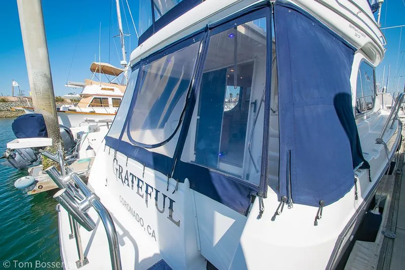 Slide: The Image of 2001 Bayliner 3788 Command Bridge Motoryacht docked with blue canvas cover. - 4