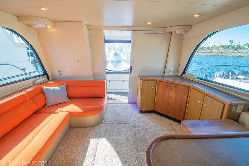 Slide: The Image of Interior of 2001 Bayliner 3788 Command Bridge Motoryacht with orange seating and waterfront view. - 9