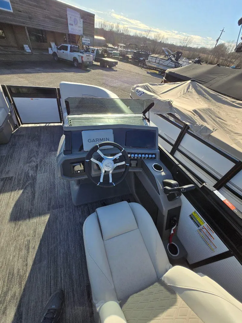 Slide: The Image of 2025 Quest L Class 20RLS boat cockpit with Garmin navigation system and steering wheel. - 8