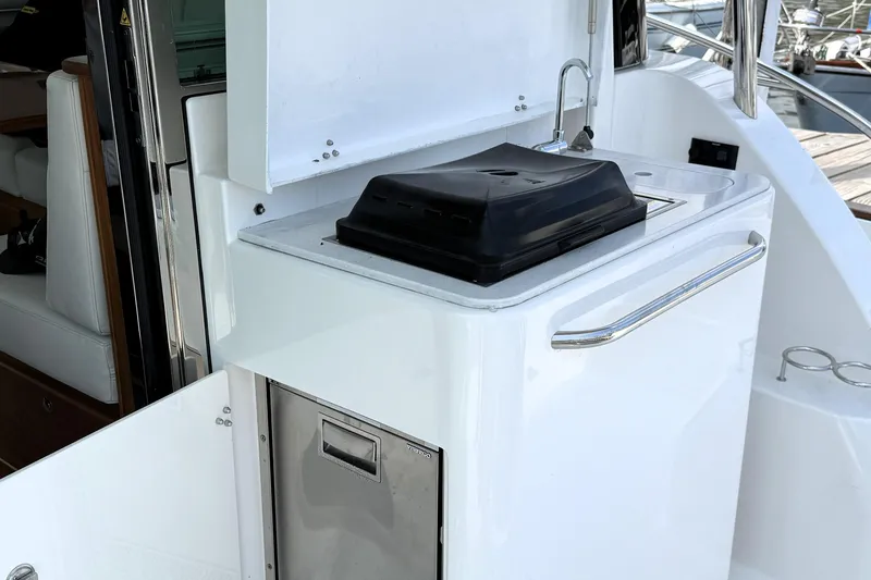 Slide: The Image of Outdoor kitchenette on 2025 Sabre 45 Salon Express yacht with grill and sink. - 10