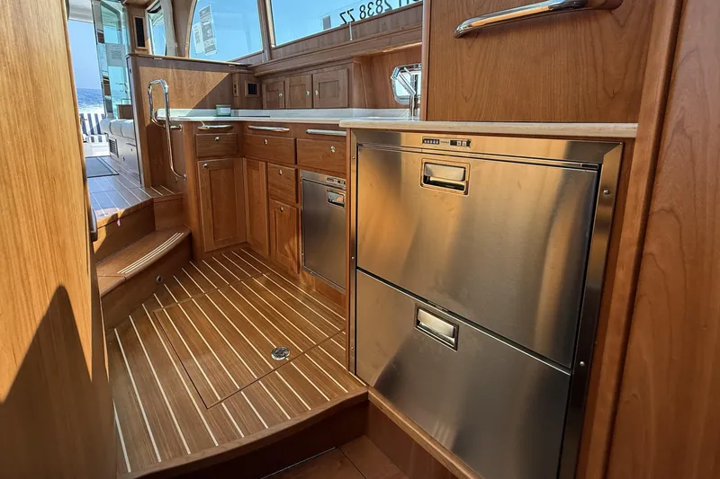 Slide: The Image of Interior of 2025 Sabre 45 Salon Express yacht with wooden cabinetry and stainless steel appliances. - 24
