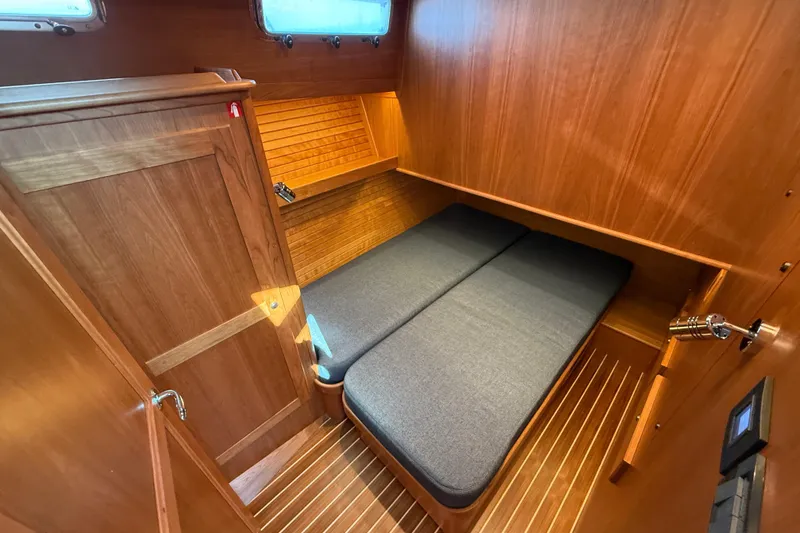 Slide: The Image of 2025 Sabre 45 Salon Express cabin with wooden interior and cozy bed. - 29