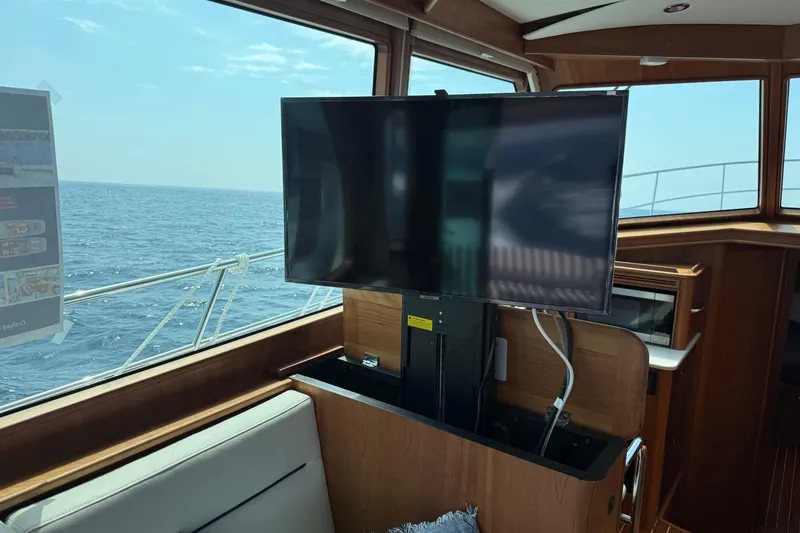 Slide: The Image of Interior of 2025 Sabre 45 Salon Express yacht with TV and ocean view. - 32