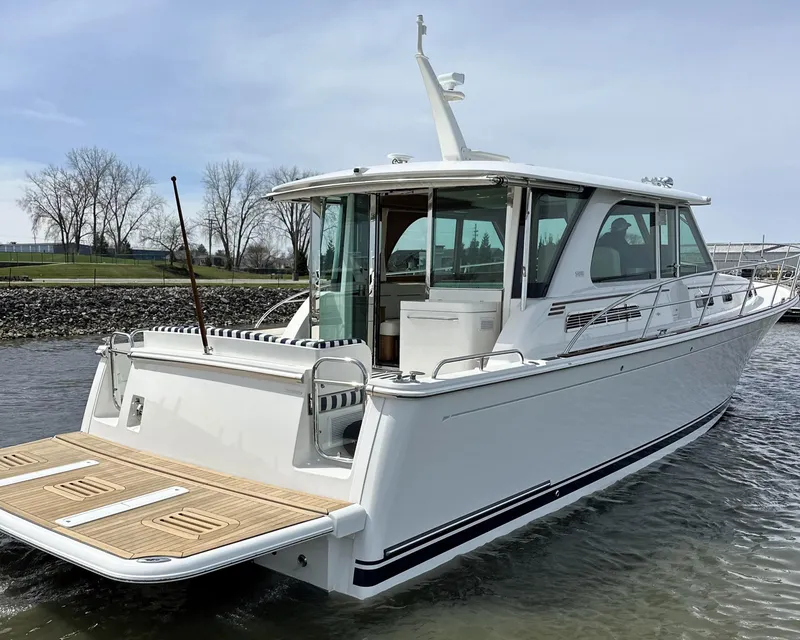 Slide: The Image of 2025 Sabre 45 Salon Express yacht on water, rear view, sleek design. - 34