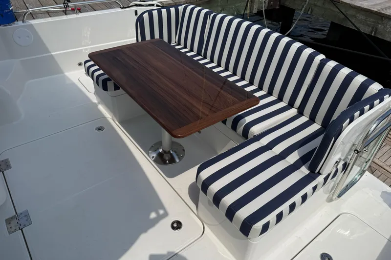 Slide: The Image of Striped seating and wooden table on 2025 Sabre 45 Salon Express yacht deck. - 7