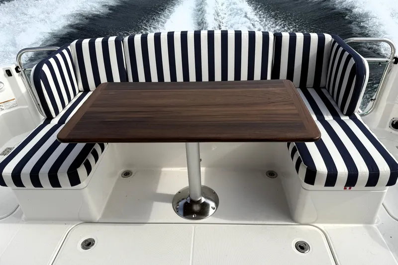 Slide: The Image of 2025 Sabre 45 Salon Express boat with striped seating and wooden table. - 9