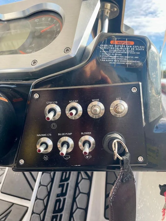 Slide: The Image of Control panel of a 2017 Scarab 165 HO boat with switches and key. - 12