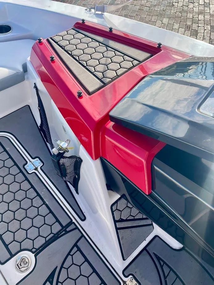 Slide: The Image of 2017 Scarab 165 HO boat interior with red accents and hexagonal pattern flooring. - 14