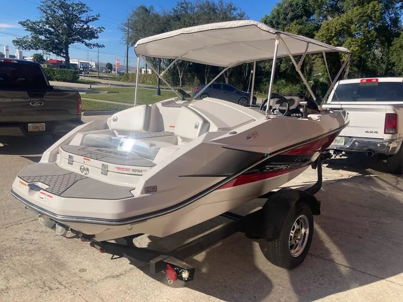 Slide: The Image of 2017 Scarab 165 HO boat with canopy on trailer, parked outdoors. - 23
