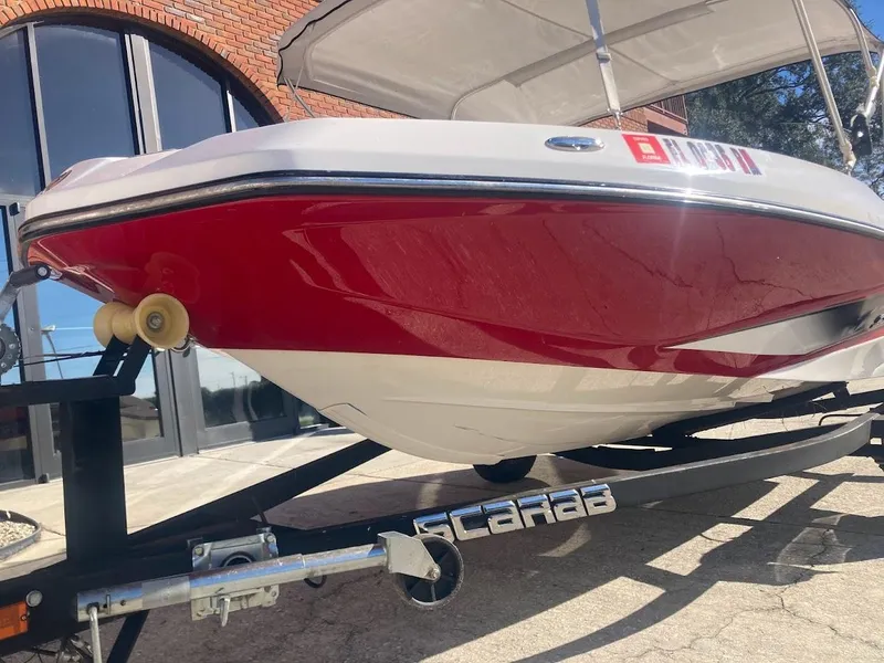 Slide: The Image of 2017 Scarab 165 HO boat on trailer, red and white design, parked outdoors. - 25
