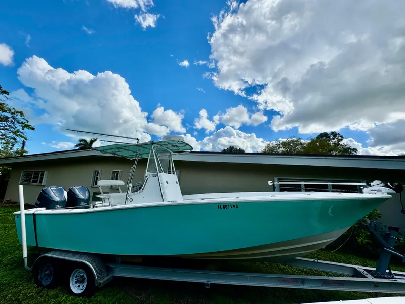 Slide: The Image of 2014 Conch 27 CC boat on trailer under cloudy sky. - 1