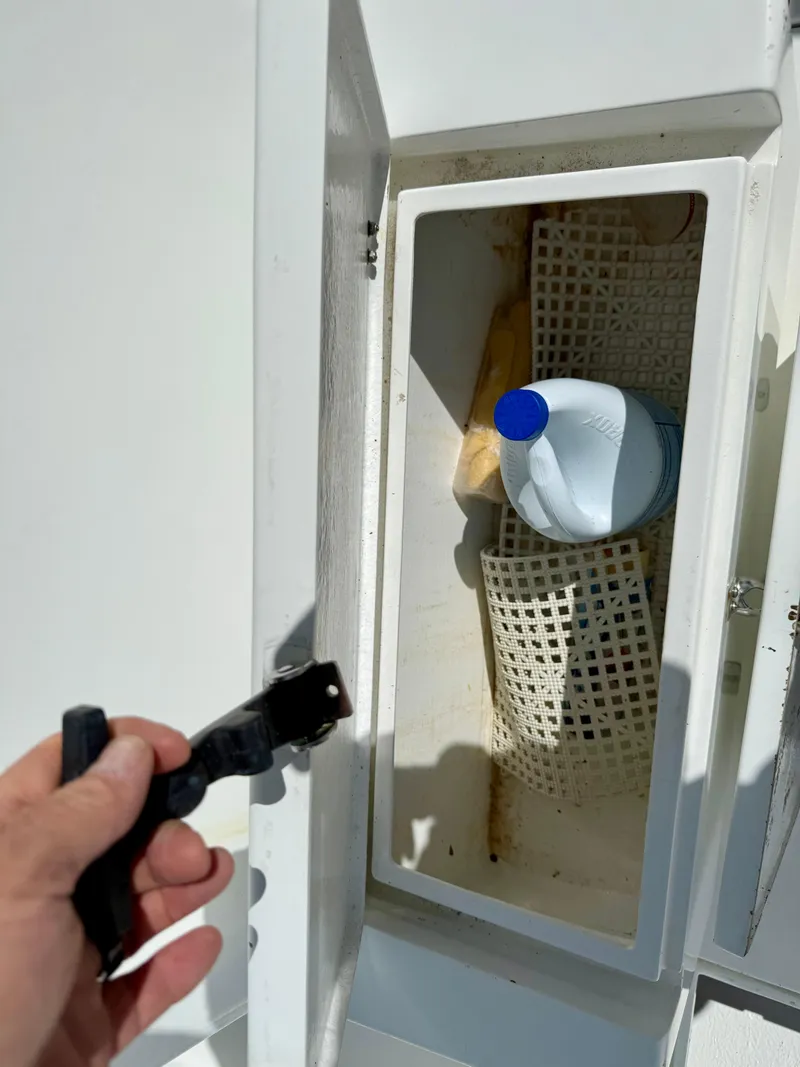 Slide: The Image of Open storage compartment on 2014 Conch 27 CC boat with cleaning supplies inside. - 11