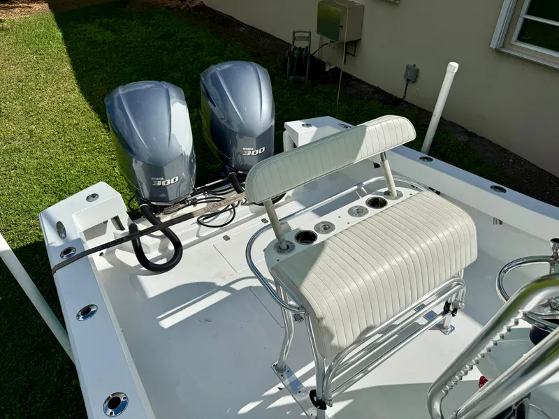 Slide: The Image of 2014 Conch 27 CC boat with dual 300 horsepower engines, white seating, and clean deck. - 2