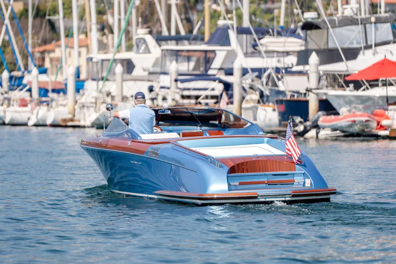 Slide: The Image of 2025 Riva Aquariva 33 luxury boat cruising in a marina, displaying sleek design and elegance. - 11