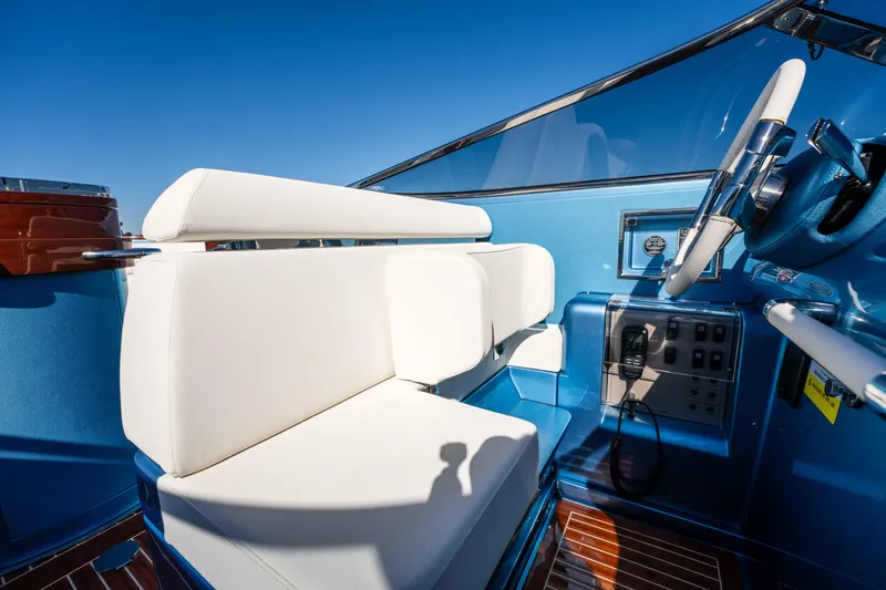 Slide: The Image of 2025 Riva Aquariva 33 interior with white seating and blue dashboard. - 20