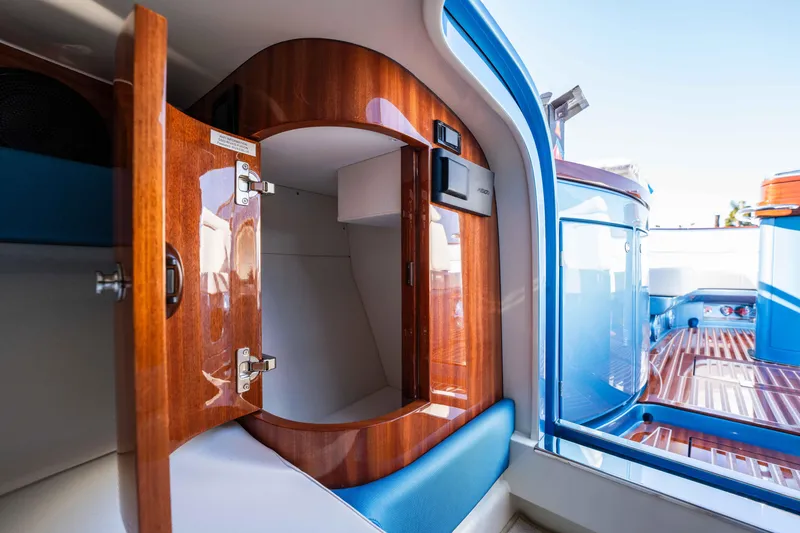 Slide: The Image of Interior of 2025 Riva Aquariva 33 yacht, featuring elegant wood cabinetry and blue seating. - 21