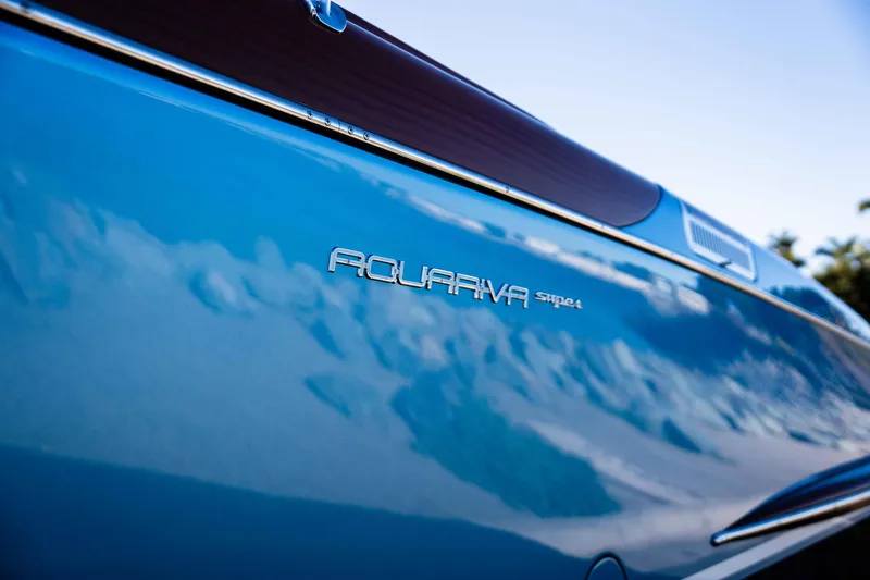 Slide: The Image of 2025 Riva Aquariva 33 boat side view with sleek blue finish and logo detail. - 23