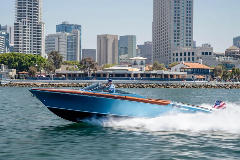 Slide: The Image of 2025 Riva Aquariva 33 speedboat cruising near urban waterfront skyline. - 5