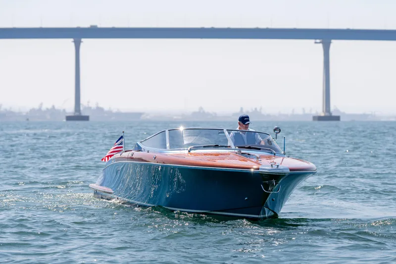 Slide: The Image of 2025 Riva Aquariva 33 cruising on water with bridge in background. - 9