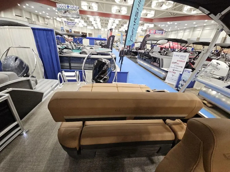 Slide: The Image of 2025 Bennington M Swingback 24 MSB pontoon boat displayed at an indoor boat show. - 6