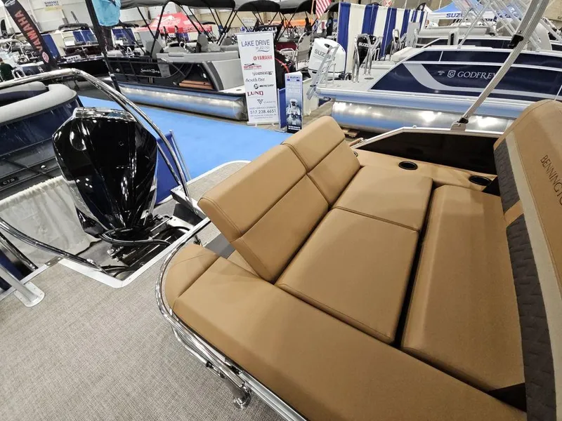 Slide: The Image of 2025 Bennington M Swingback 24 MSB boat with tan seating at a boat show. - 8