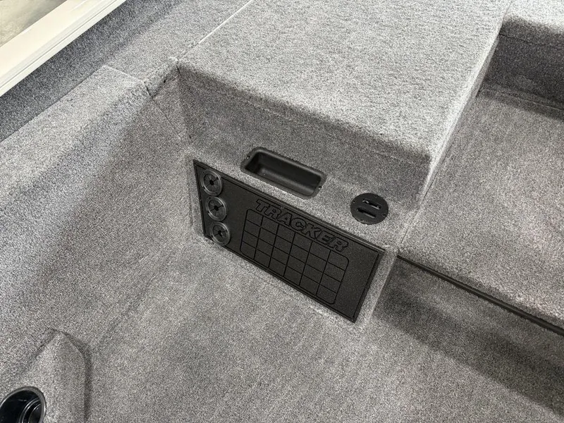 Slide: The Image of 2025 Tracker Savage 215 boat interior with gray carpet and storage compartment. - 11