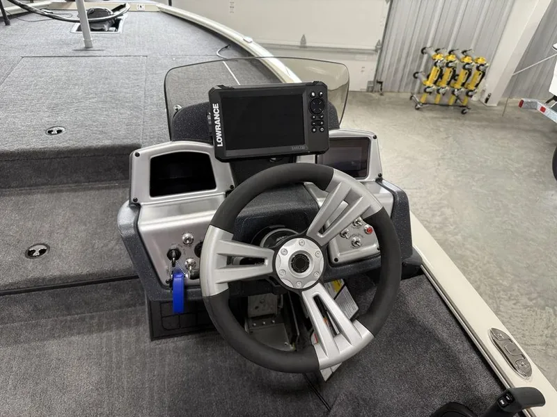 Slide: The Image of 2025 Tracker Savage 215 boat dashboard with steering wheel and Lowrance display. - 14