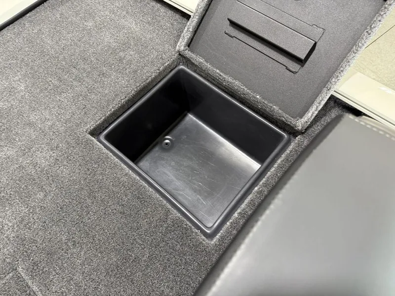 Slide: The Image of Storage compartment in 2025 Tracker Savage 215 boat, featuring a carpeted interior. - 16