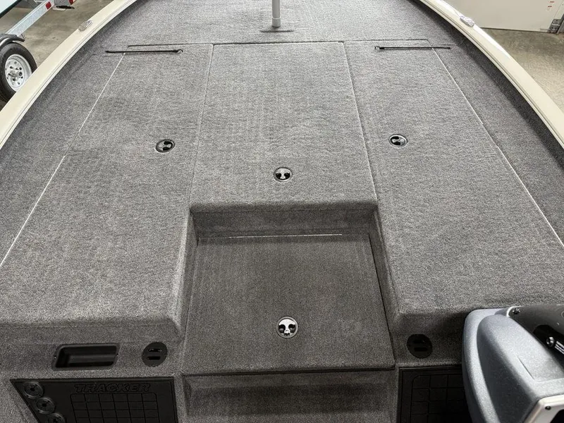 Slide: The Image of 2025 Tracker Savage 215 boat deck with gray carpet and storage compartments. - 7