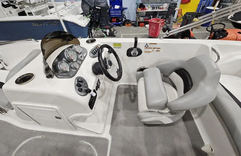Slide: The Image of Interior of a 2014 Starcraft Limited IO 2000 I/O boat, featuring steering console and seating. - 8