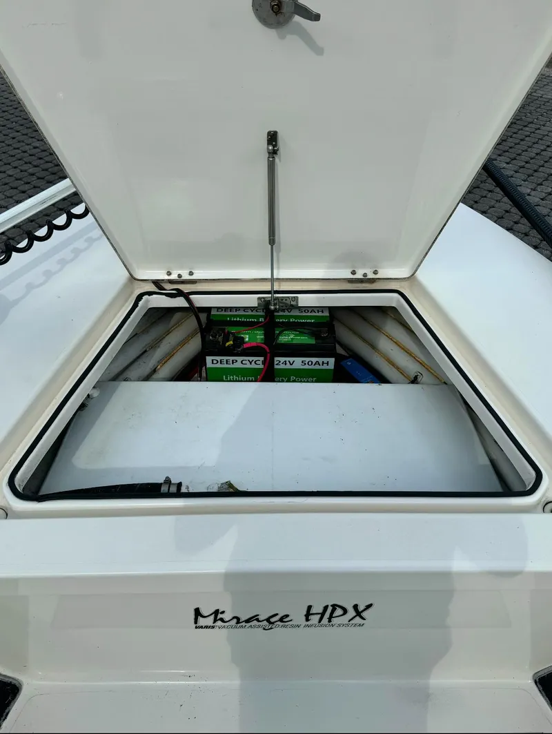Slide: The Image of Open storage compartment of 2012 Maverick Mirage 18 HPX-V boat, showing batteries and wiring. - 14