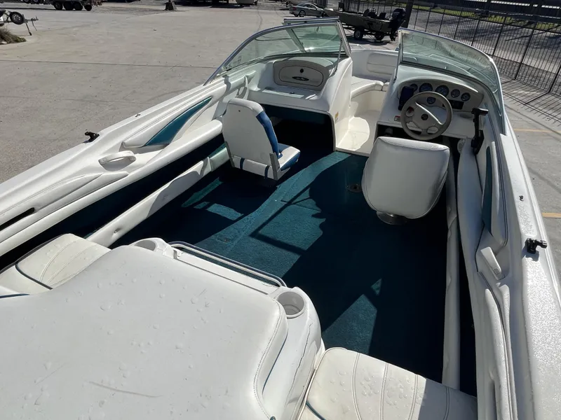 Slide: The Image of 1997 Sea Ray 185 boat interior with white seats and blue carpet. - 12