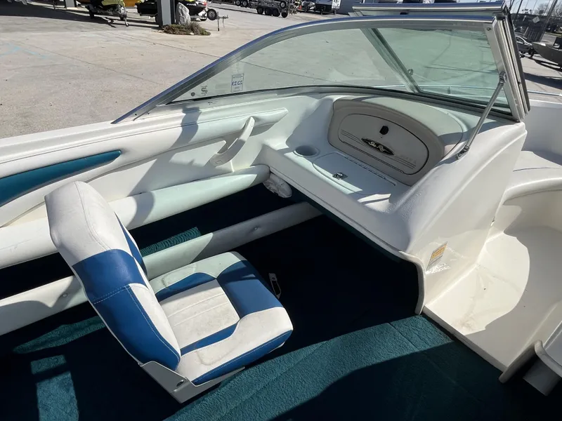 Slide: The Image of Interior of a 1997 Sea Ray 185 boat with blue and white seating. - 13