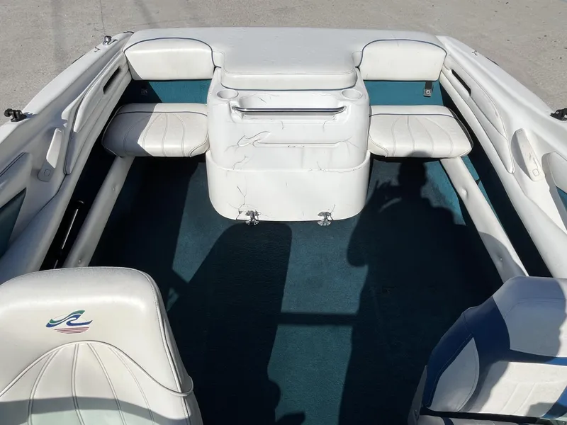 Slide: The Image of Interior of a 1997 Sea Ray 185 boat with white seating and blue carpet. - 14