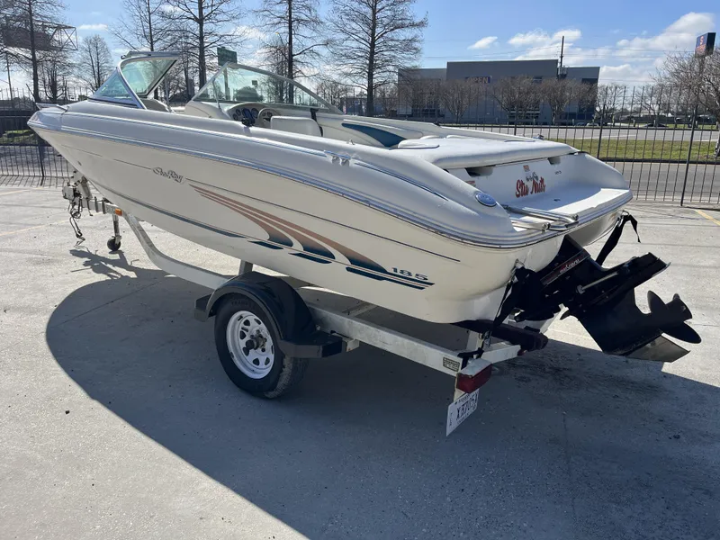 Slide: The Image of 1997 Sea Ray 185 boat on trailer, parked outdoors, sunny day. - 4