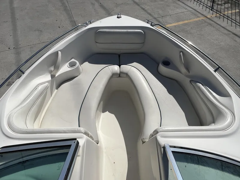 Slide: The Image of 1997 Sea Ray 185 boat interior with white cushioned seating and cup holders. - 7