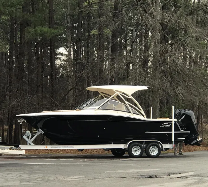 Slide: The Image of 2019 Scout 255 Dorado boat on trailer in wooded area. - 14