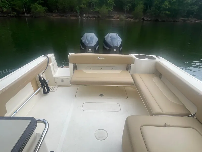 Slide: The Image of 2019 Scout 255 Dorado boat interior with dual outboard motors on a calm lake. - 15
