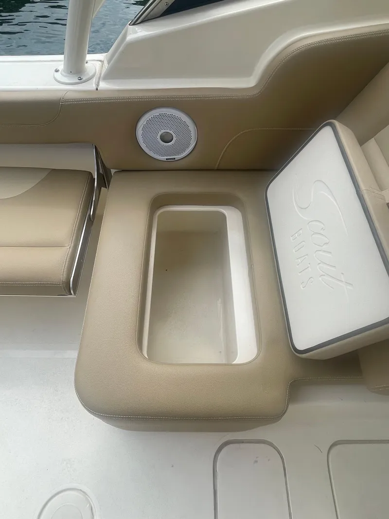 Slide: The Image of 2019 Scout 255 Dorado boat interior with beige seating and storage compartment. - 19