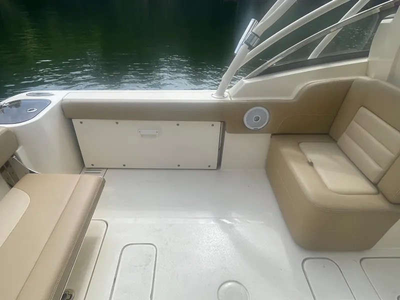 Slide: The Image of 2019 Scout 255 Dorado boat interior with beige seating and water view. - 21