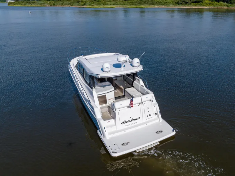Slide: The Image of 2021 Regal 38 Grande Coupe yacht cruising on calm waters. - 16