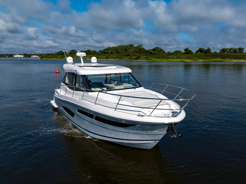 Slide: The Image of 2021 Regal 38 Grande Coupe cruising on a calm river under a cloudy sky. - 23
