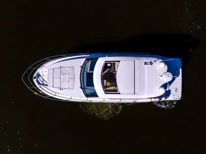 Slide: The Image of Aerial view of 2021 Regal 38 Grande Coupe yacht cruising on dark water. - 24