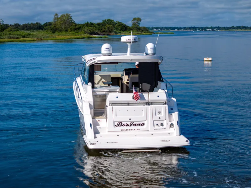Slide: The Image of 2021 Regal 38 Grande Coupe cruising on a serene lake with lush greenery. - 25