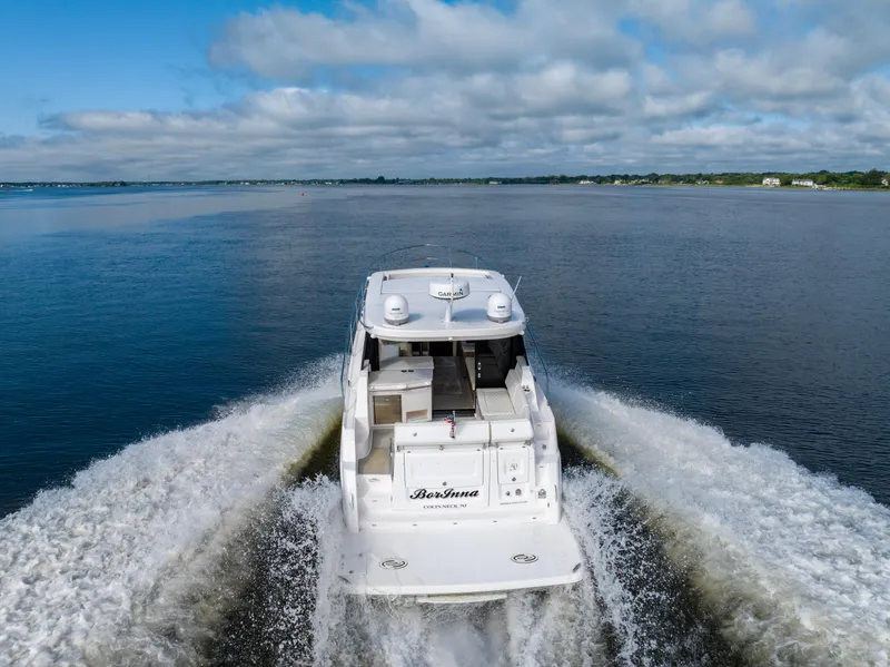 Slide: The Image of 2021 Regal 38 Grande Coupe cruising on open water under a cloudy sky. - 37
