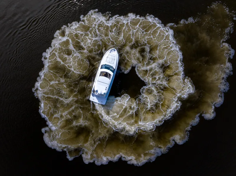 Slide: The Image of Aerial view of 2021 Regal 38 Grande Coupe creating circular wake pattern on water. - 39