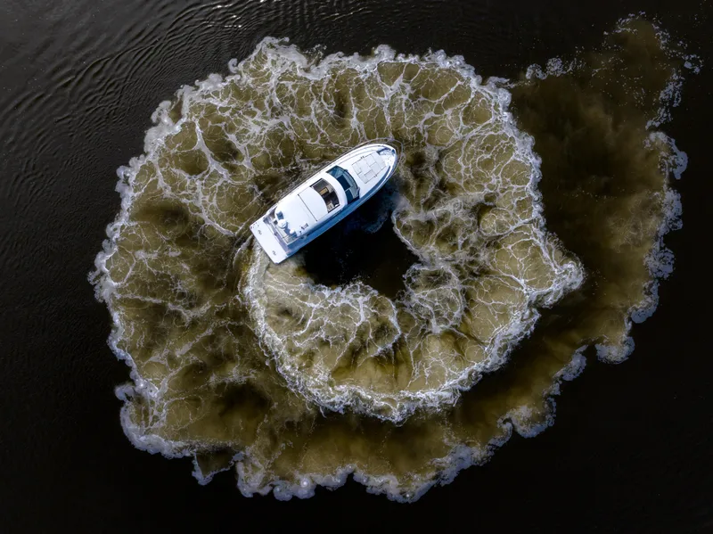 Slide: The Image of Aerial view of 2021 Regal 38 Grande Coupe creating circular wake pattern on water. - 40