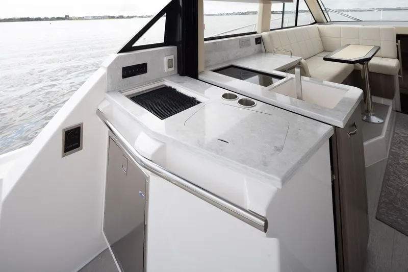 Slide: The Image of 2021 Regal 38 Grande Coupe yacht interior with modern kitchen and seating area. - 45